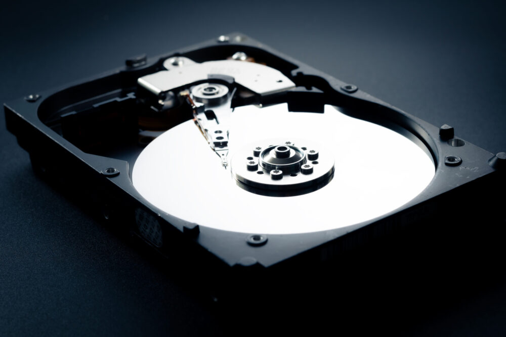 Disassembled open hard disk drive HDD of computer or laptop. Place it on a dark matt background. the concept of data, hardware, and information technology